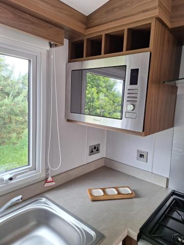 a kitchen with a sink and a microwave at Northern Lights in Lossiemouth