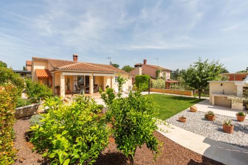 a house with a yard with bushes and trees at Casa Tatjana in Rošini