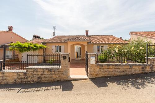 a house with a gate and a brick fence at Casa Tatjana in Rošini