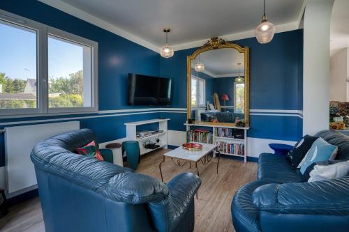 a blue living room with two blue couches and a mirror at Plage à 300 m, piscine 29 degrés, 5 chambres, 4 sdb, calme in Bénodet