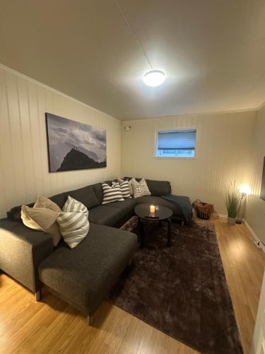 a living room with a couch and a table at Lofoten Retreat Apartment in Leknes