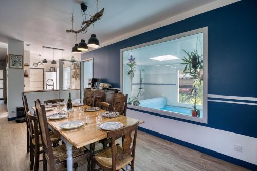 une salle à manger avec une table et un mur bleu dans l'établissement Beach at 300 m, swimming pool 29 Celsuis, 5 bedrooms, 4 bathrooms, quiet, à Bénodet