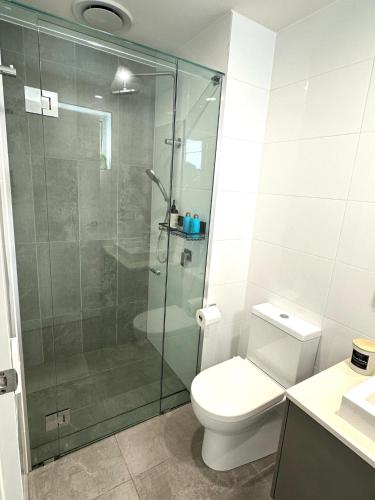 a bathroom with a toilet and a glass shower at 2bedroom 2bath in Garden city in Brisbane