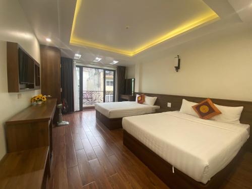 a hotel room with two beds and a television at MAI VANG Hotel in Sapa