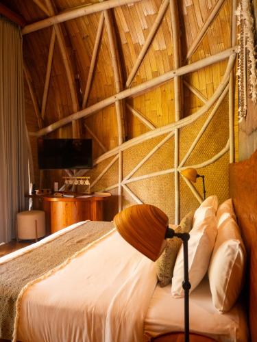 a bedroom with a bed with a wooden ceiling at Ulaman Eco Luxury Resort in Tabanan