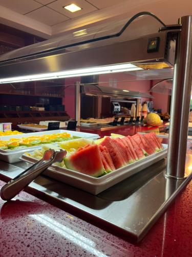 een buffetlijn met een schaal watermeloen en andere gerechten bij Apartamentos Atlántico Resort in Montalvo