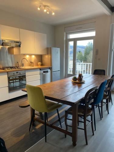 - une cuisine avec une table à manger en bois et des chaises dans l'établissement Agréable maison avec vue panoramique, à La Bourboule