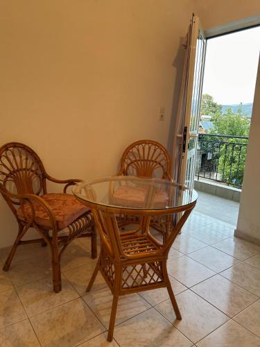a dining room with a glass table and two chairs at Άρπυια in Kakóvatos