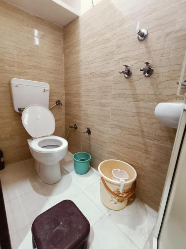 a bathroom with a toilet and a sink at Sankalp Yatri Nivas AC dormitory in Gwalior