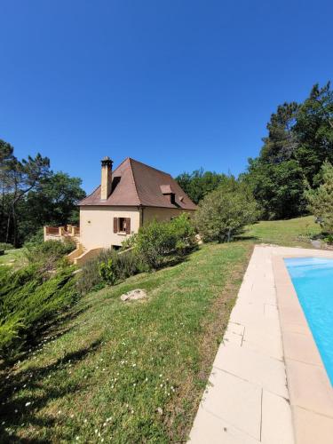 une maison et une piscine devant une maison dans l'établissement Maison du Morilhou, à Auriac-du-Périgord