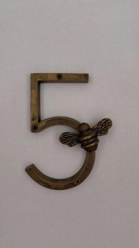 a metal number on a wall with a bow at Ivy Ayvalık Butik Otel in Ayvalık