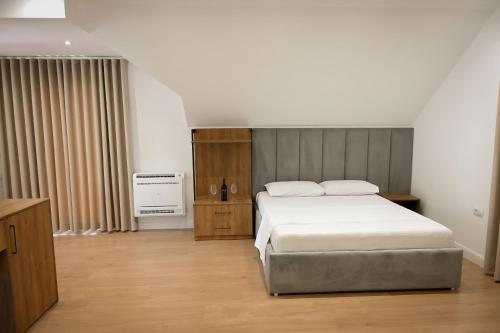 a bedroom with a white bed and a radiator at Vila Venezia in Shëngjin