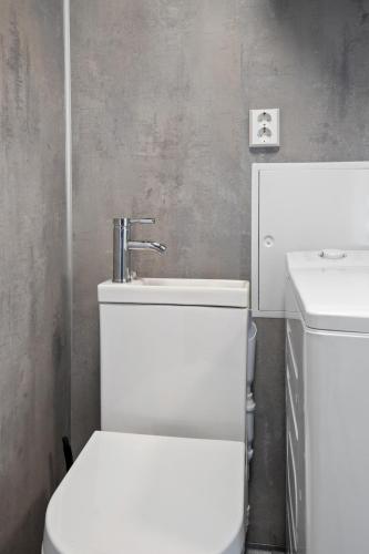 a bathroom with a white toilet and a sink at EcoStay Comfort in compact format nr three in Horten