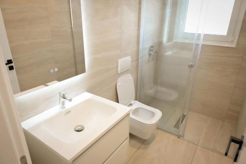 a bathroom with a sink and a toilet and a shower at Vila Venezia in Shëngjin