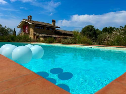 a swimming pool with white balloons in front of a house at Nonna Nara Bed & Breakfast in Grosseto