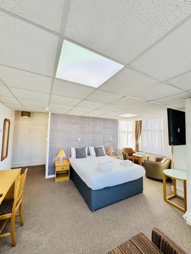a bedroom with a bed and a tv in a room at Carlton Court Hotel Eastbourne in Eastbourne