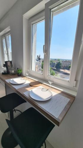 un bureau en bois avec une fenêtre et une table avec des chaises dans l'établissement Sur la savoureuse - Le 21, à Belfort