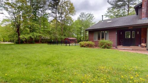 a house with a green yard next to a house at Sugar Hollow home in Chittenden
