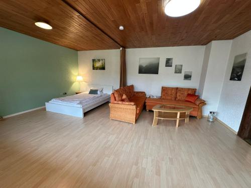 a living room with a bed and a couch and a table at Ferienwohnung "FeWo am Bach" - Pegnitz in Pegnitz