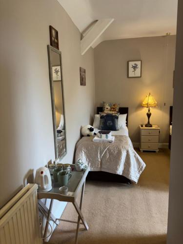 a bedroom with a bed and a table and a mirror at Simonburn Bed and Breakfast 