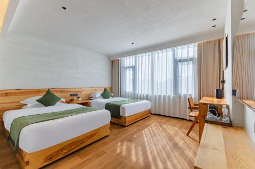 Una cama o camas en una habitación de Huangshan Tunxi Shangjiexing Riverview Resort Hotel