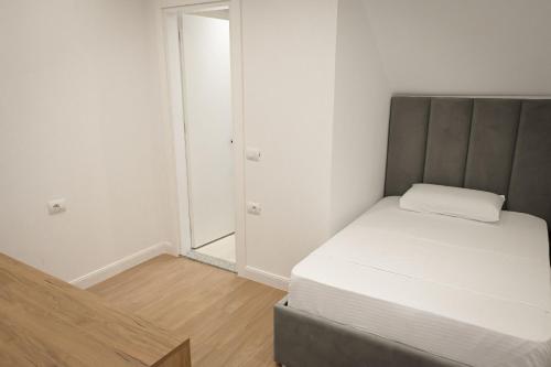 a small bedroom with a bed and a mirror at Vila Venezia in Shëngjin