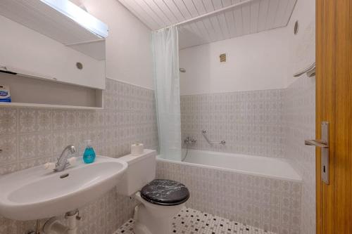 a white bathroom with a sink and a toilet at Breithorn View in Täsch