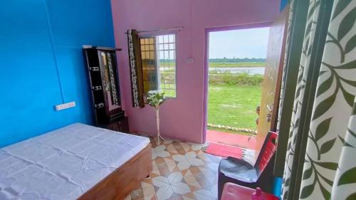 a bedroom with a bed and a window and a chair at Poddar Retreat in Mal bazar