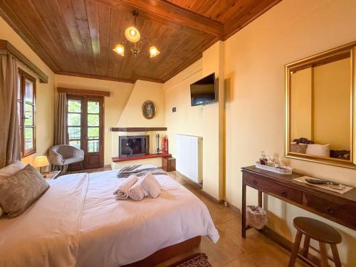 a bedroom with a large bed and a mirror at Pliades Traditional Guesthouse in Palaios Panteleimon