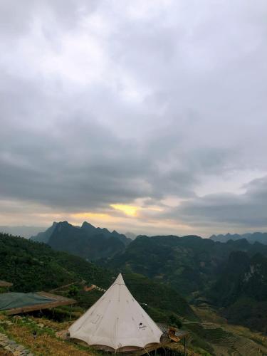 a white tent sitting on top of a mountain at Sunrise Ha Giang Camping An Introspective Stay in Suy Tung Su