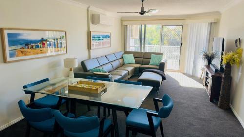 a living room with a couch and a table and chairs at Fairways Golf & Beach Retreat Bribie Island in Woorim