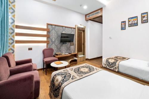 a hotel room with two beds and a tv at PRIME LAND in Varanasi