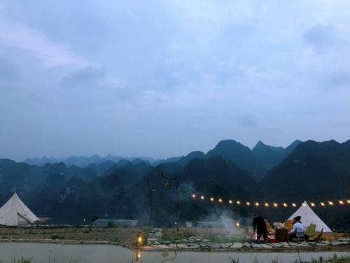 a group of people standing in front of tents at Sunrise Ha Giang Camping An Introspective Stay in Suy Tung Su