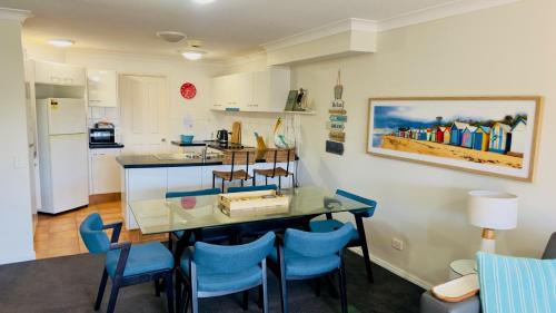 a kitchen and dining room with a table and chairs at Fairways Golf & Beach Retreat Bribie Island in Woorim