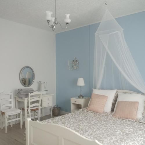- une chambre avec un lit blanc, une table et un bureau dans l'établissement B&B at 3 La Brionniere, à Saint-Pierre-du-Chemin