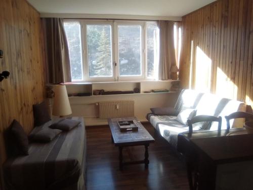 un salon avec un canapé et une table dans l'établissement Joli studio aux pieds des pistes, à Allos