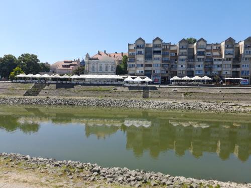 a body of water with buildings in the background at Koleos in Osijek