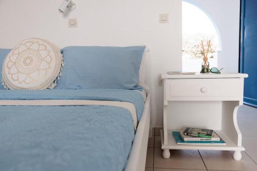 a bed with a blue blanket and a white night stand at Aurea Blu Studio 10 Dreaming, beach, tranquility, sea in Aliko Beach