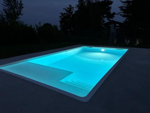 a swimming pool lit up at night at All'Antica Scuderia Del Castello in Maiano