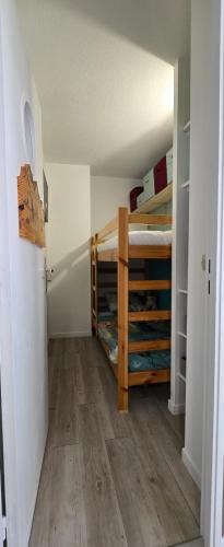 Cette chambre comprend 2 lits superposés et un couloir. dans l'établissement Appartement 3 pièces Luchon, à Luchon
