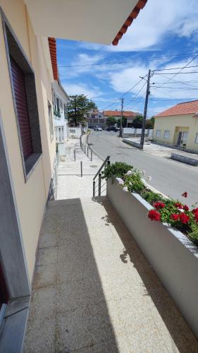 a sidewalk next to a building with flowers on a street at A Casa das Tias in Benedita