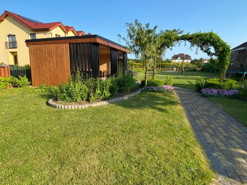 a garden with a small building in a yard at Laguna Blue in Grzybowo