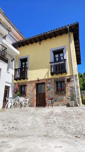 a building with a table and chairs in front of it at La Casina de la Caleyona, Parres - Llanes in Llanes