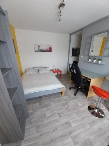 une chambre avec un lit, un bureau et une chaise dans l'établissement Studio Beauséjour, à Niort