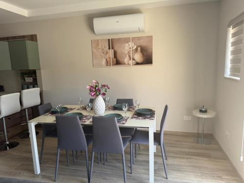 a dining room with a white table and chairs at Wardija Heights Luxury Penthouse in Qala