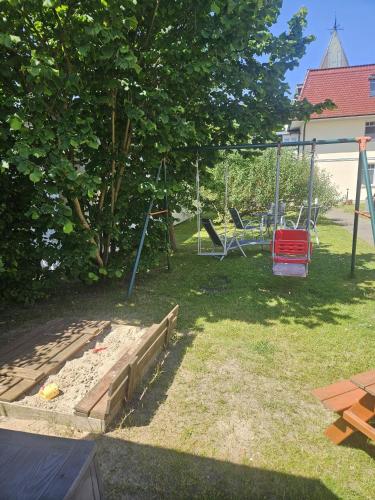a yard with a swing set and a playground at Villa Viktoria Whg 3 - "Liegeplatz" in Kölpinsee