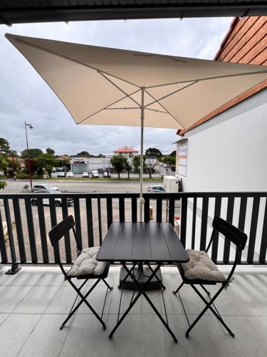 d'une table et de deux chaises avec un parasol sur le balcon. dans l'établissement Studio rénové proche de la plage, à Tarnos