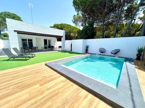 una piscina en el patio trasero de una casa en Chalet Empul Los Pinares, en Chiclana de la Frontera