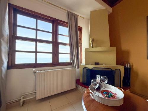 a room with a table with glasses and a window at Pliades Traditional Guesthouse in Palaios Panteleimon