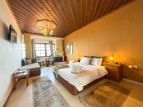 a large bedroom with a large bed and a couch at Pliades Traditional Guesthouse in Palaios Panteleimon